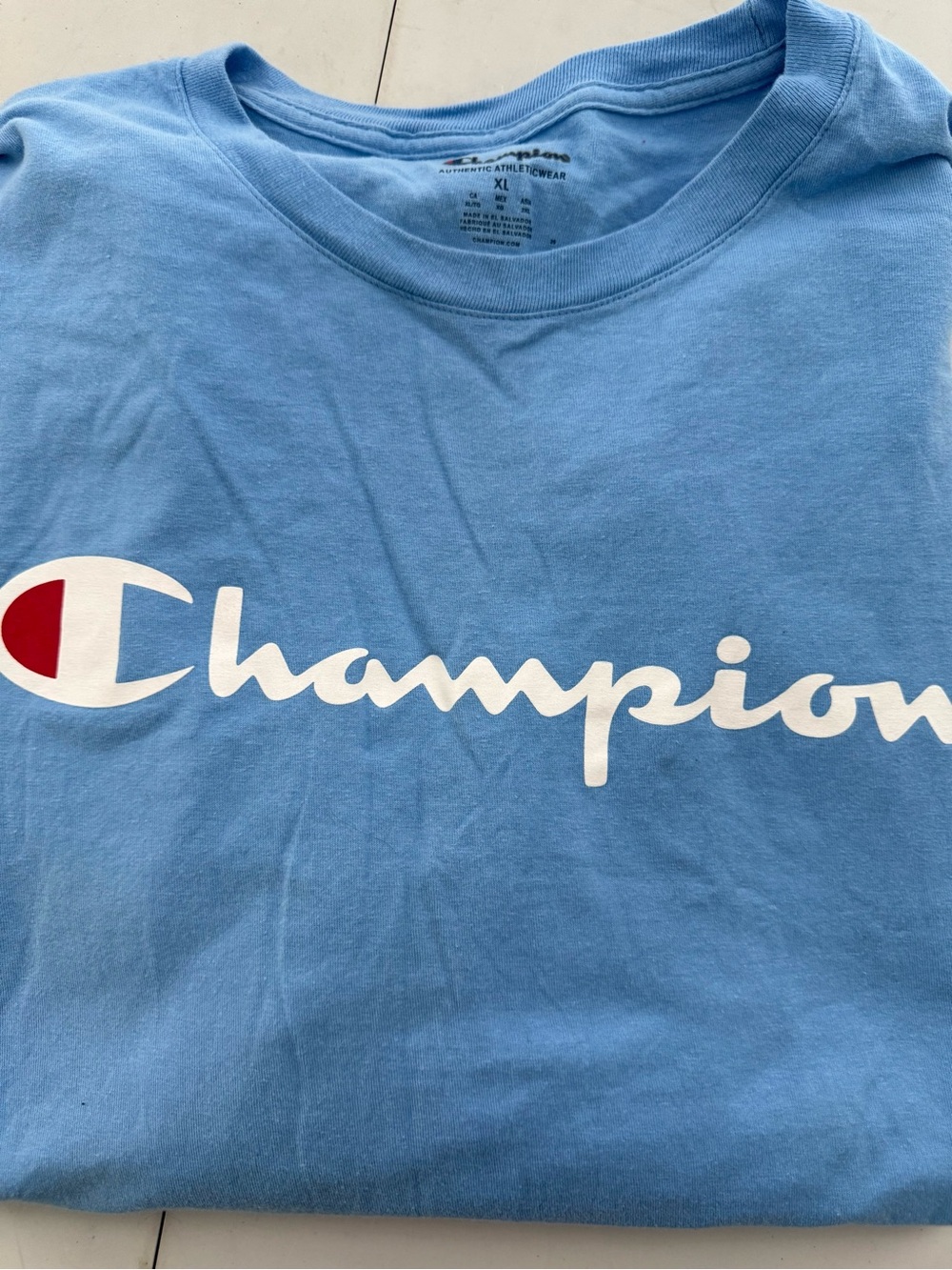Champion Light Blue Tee with White Script Logo and Red Accent